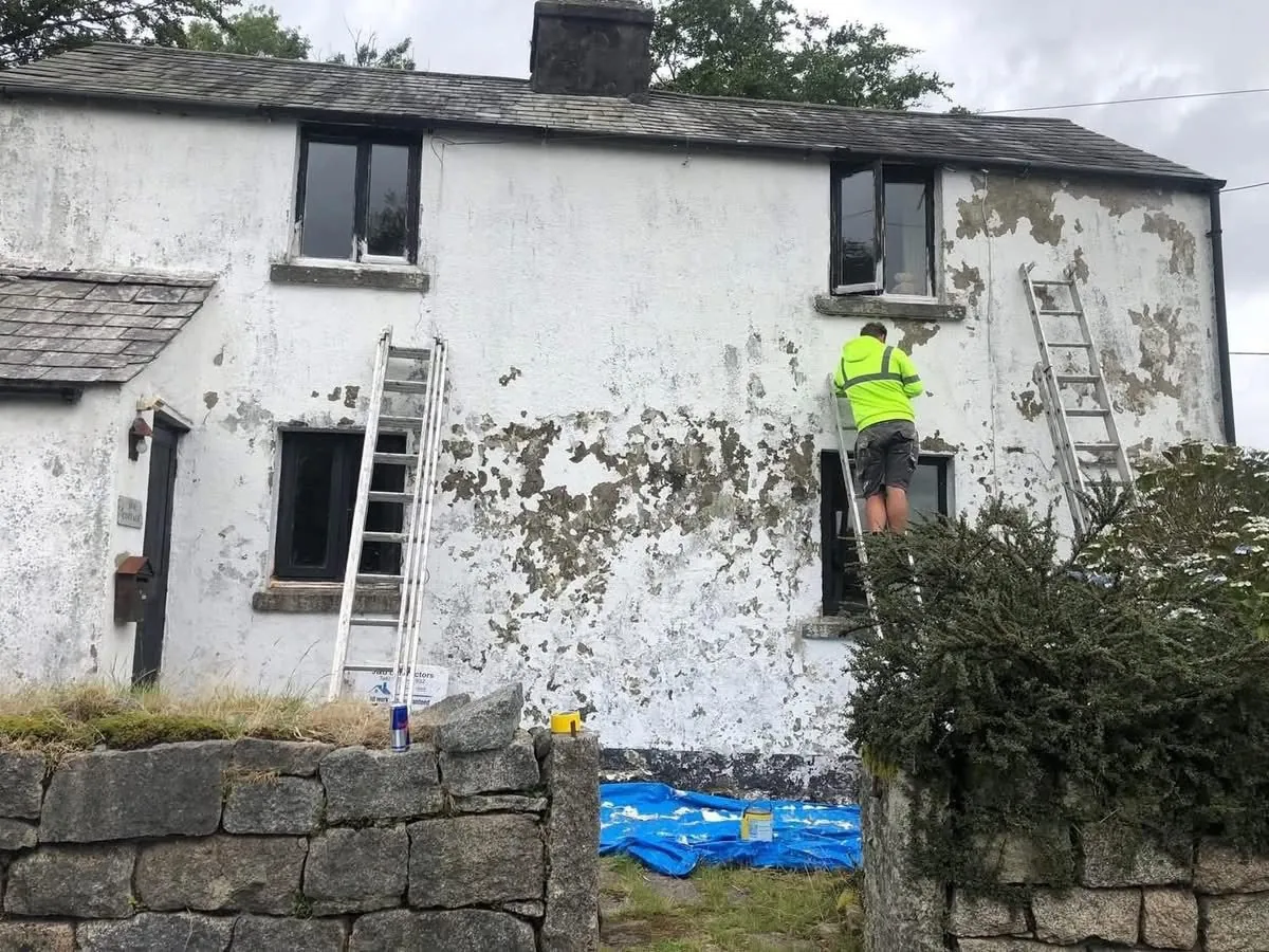 Cottage with blown, flaking render before repair in Seaton